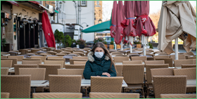 Communiqué de presse pour le Focus de Coface sur les défaillances en Allemagne. La photo montre une femme portant un masque, assise seule à la terrasse d'un café à Cologne, en Allemagne.