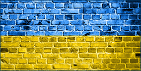 Coface Focus: Economic consequences of the Russia-Ukraine conflict: Stagflation ahead. Image of a brick wall with a blue and yellow overlay to match the national flag of Ukraine 